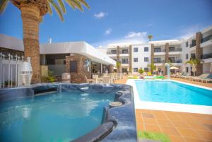 a swimming pool in front of a hotel at Club Atlántico in Puerto del Carmen