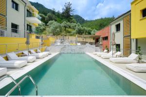 a swimming pool with chaise lounge chairs next to a building at Serenity Apartments in Skala Potamias