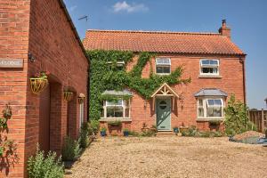 a brick house with a green door and ivy at Oaklodge in Spilsby