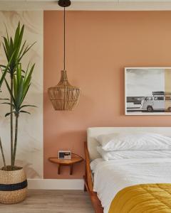 ein Schlafzimmer mit einem Bett und einer Topfpflanze in der Unterkunft The June Motel in Sauble Beach
