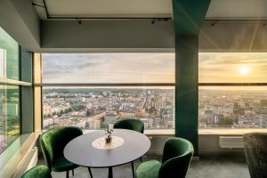 a table and chairs in a room with a large window at Sea Towers Panoramic Penthouse in Gdynia