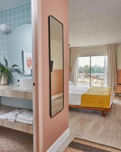 1 dormitorio con cama y espejo en la pared en The June Motel, en Sauble Beach