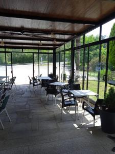 patio ze stołami, krzesłami i oknami w obiekcie O castiñeiro w mieście Cerdedo +1 zdjęcie