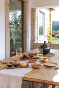 - une table avec des verres de vin et de la nourriture dans l'établissement Quintal Country Houses, à Vila Praia de Âncora
