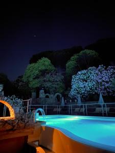 Agriturismo La Sorgente di Rossi Valentino في Larciano: حمام سباحة في الليل مع أضواء زرقاء