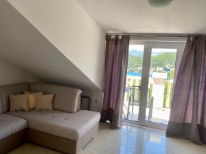 a living room with a couch and a sliding glass door at Apartmani Luka in Korčula