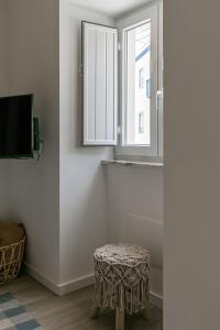 Zimmer mit einem Hocker und einem Fenster in der Unterkunft Casa da Saudade in Ferrel