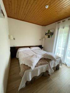 Hotel Avet في La Coma i la Pedra: غرفة نوم بسرير وسقف خشبي