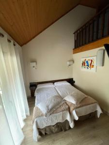 Hotel Avet في La Coma i la Pedra: غرفة نوم بسرير ذو شراشف بيضاء وسقف خشبي