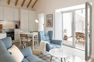 a living room with blue chairs and a table at Casa da Saudade in Ferrel