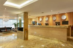 a lobby with clocks on the wall and a reception counter at Windsor Copa Hotel in Rio de Janeiro