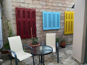 a table and two chairs and a wall with colorful shutters at The Lagoon Luxury House in Argostoli