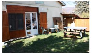 a patio with a table and chairs in a yard at petit studio, bien équipé, à la campagne in Marcoux
