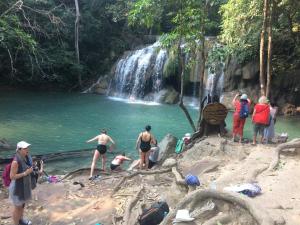 a group of people standing near a waterfall at Thanya Mansion in Kanchanaburi City