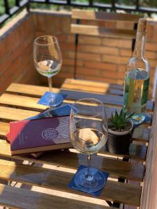 dos copas de vino en una mesa con una botella de vino en FAISÁN 20 Apartamento, en Granada