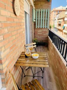 - une table en bois avec deux verres de vin sur le balcon dans l'établissement FAISÁN 20 Apartamento, à Grenade