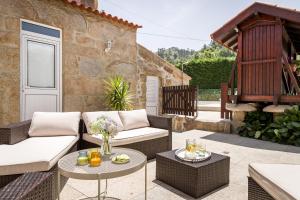 un patio con 2 sofás y una mesa en Casa de Ferreira Cinfães, en Cinfães