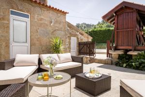 a patio with two couches and a table at Casa de Ferreira Cinfães in Cinfães