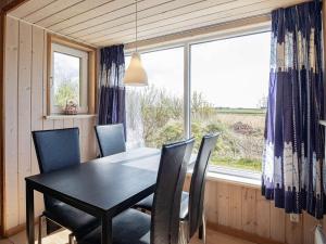 uma sala de jantar com uma mesa e cadeiras e uma janela em Holiday home Thyholm XVI em Thyholm