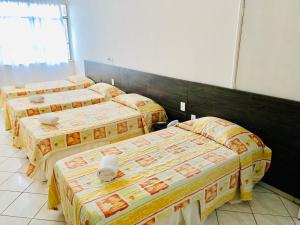 a group of three beds in a room at HANNA Arcos d'Atalaia Hotel - Aracaju in Aracaju