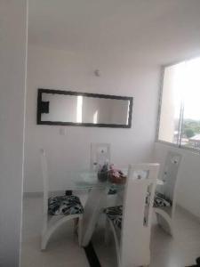 a white room with a glass table and two chairs at Apartamento amplio y tranquilo en Flandes, Tolima in Flandes