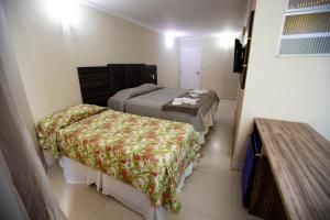 a hotel room with two beds and a table at HANNA Arcos d'Atalaia Hotel - Aracaju in Aracaju