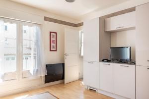 uma sala de estar com armários brancos e uma televisão em Charmant T2 proximité Paquebot-les Halles em Saint-Nazaire