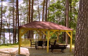 a gazebo with a table and chairs in the woods at Ruciane Tarasy in Ruciane-Nida +26 photos