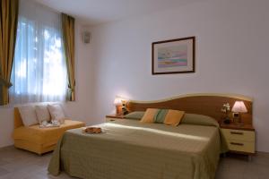 a hotel room with a bed and a window at Hotel I Ginepri in Marina di Castagneto Carducci