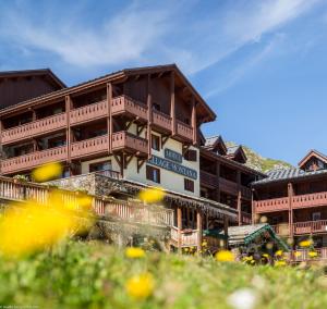 a large building with wooden balconies on a mountain at Hôtel Village Montana by Les Etincelles in Tignes
