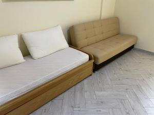 two beds and a couch in a room at Residence _Capo Gallo in Palermo