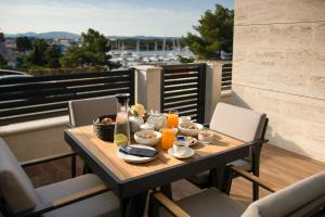 einen Tisch mit Speisen und Getränken auf dem Balkon in der Unterkunft Luxury apartment Vista del Sole in Šibenik