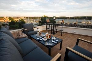 ein Wohnzimmer mit einem Sofa und einem Tisch auf dem Balkon in der Unterkunft Luxury apartment Vista del Sole in Šibenik