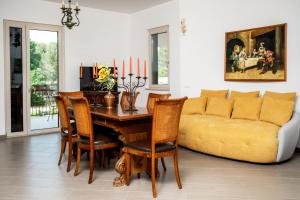 ein Wohnzimmer mit einem Tisch und einem gelben Sofa in der Unterkunft Villa degli Artisti in Selva di Fasano