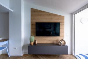 ポルト・アッズッロにあるPorto Azzurro Suite - Goelbaのリビングルーム(壁にテレビ付)