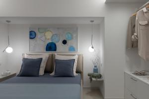 a bedroom with a blue bed and a painting on the wall at Porto Azzurro Suite - Goelba in Porto Azzurro