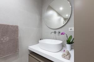 a white bathroom with a sink and a mirror at Porto Azzurro Suite - Goelba in Porto Azzurro +19 photos