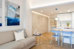 ein Wohnzimmer und eine Küche mit einem Sofa und einem Tisch in der Unterkunft Porto Azzurro Suite - Goelba in Porto Azzurro