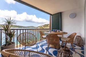 einen Balkon mit einem Tisch und Stühlen sowie Meerblick in der Unterkunft Porto Azzurro Suite - Goelba in Porto Azzurro