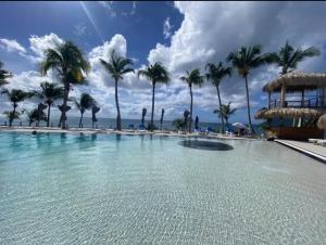 uma grande piscina com palmeiras e o oceano em Studio Alonya - Marinotel Diamant em Le Diamant mais 8 fotografias