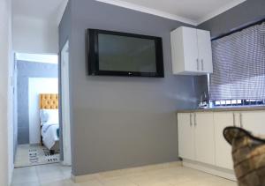 a kitchen with a flat screen tv on the wall at Pixie Lodge in Cape Town