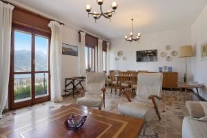 ein Wohnzimmer mit einem Tisch und Stühlen sowie ein Esszimmer in der Unterkunft Villa Carolina in San Felice del Benaco