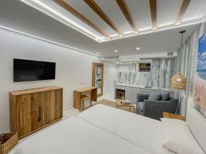 a living room with a couch and a tv on a wall at Gran Marina Suites in Las Palmas de Gran Canaria