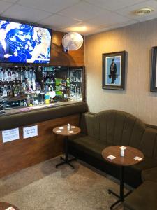 a restaurant with two tables and a bar with a tv at Springfield Hotel in Blackpool