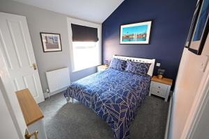 Dormitorio azul con cama y ventana en The Hathaways, en Stratford-upon-Avon