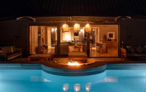 a swimming pool with a fireplace in a living room at Future Found Sanctuary by NEWMARK in Cape Town