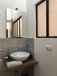 een badkamer met een wastafel en 2 spiegels bij Domus Alice in Monserrato