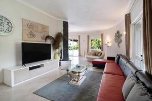 a living room with a red couch and a flat screen tv at Casa Vilamoura in Vilamoura