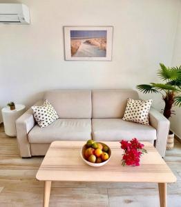 a living room with a couch and a bowl of fruit at Maracuja 17, Orient Bay village, walkable beach at 100m in Orient Bay