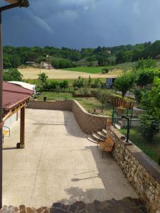 a walkway with benches and a stone wall at Una Casetta InterVineas in Spoleto